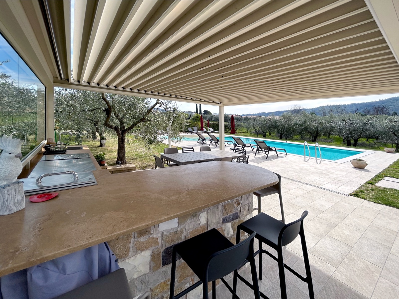 Pergola bioclimatica con cucina outdoor a bordo piscina